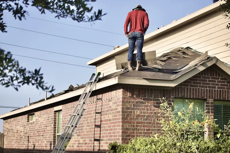 Professional roofer working on a residential roof in Tripp